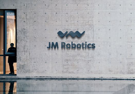 Betongvegg med logoen til JM Robotics